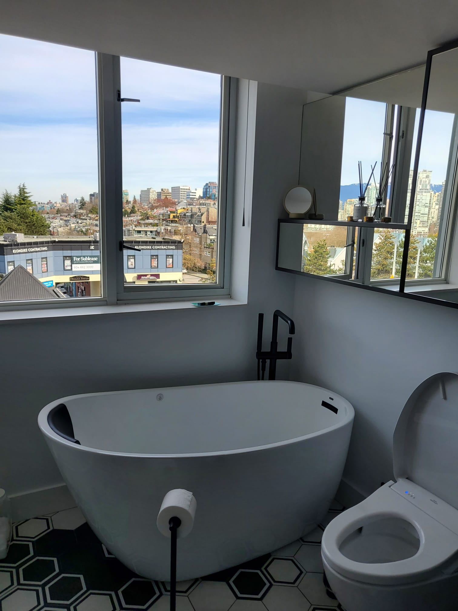 Freestanding soaker tub beside corner windows