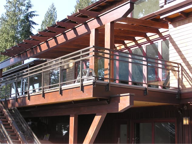 Stained cedar pergola over an elevated deck with glass railing