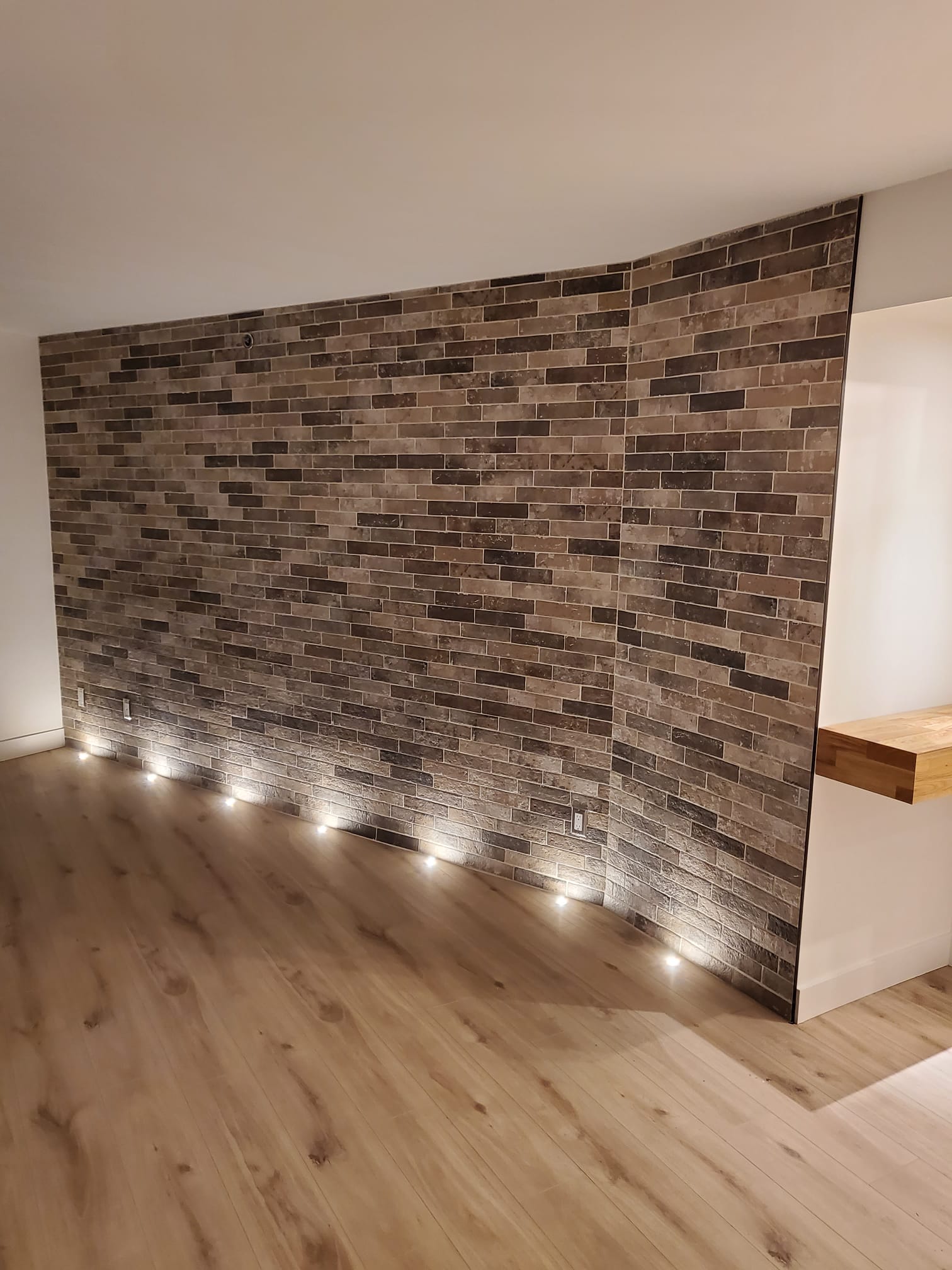 Brick veneer feature wall with floor-level uplighting