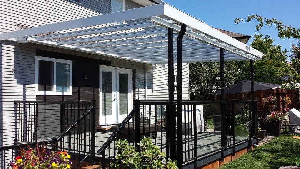 White framed glass patio cover over a deck with railing