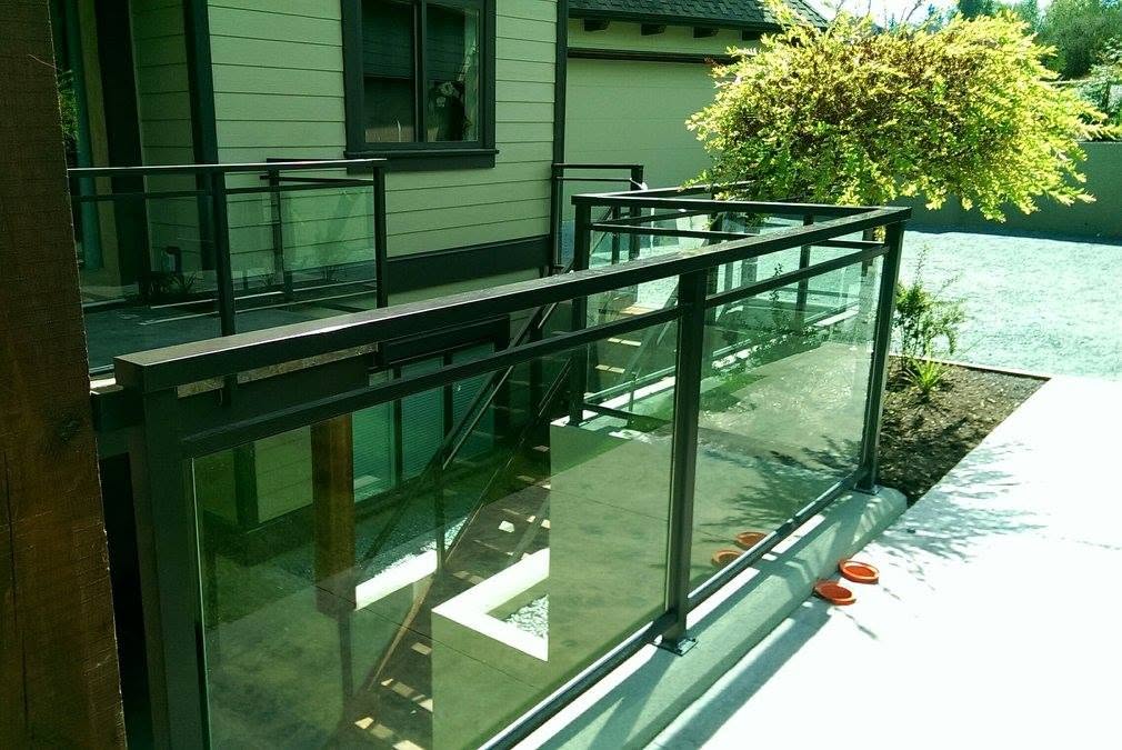 Black framed glass railing beside a walkway