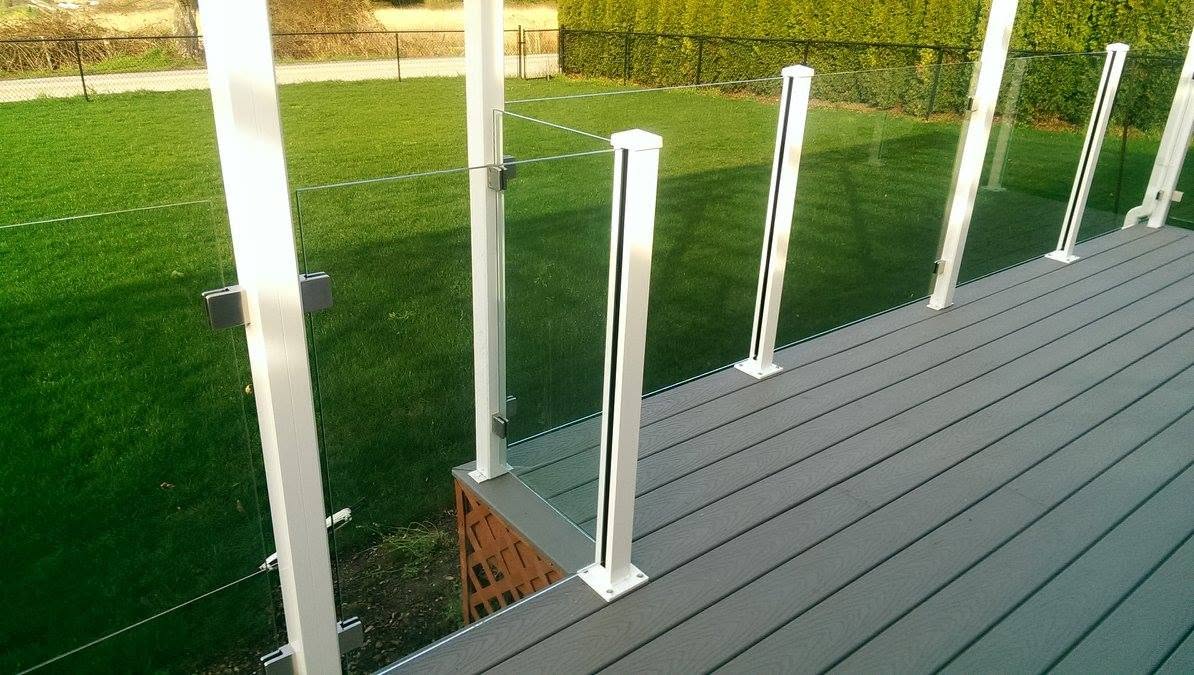 Glass railing with white posts on grey composite decking